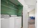 Convenient laundry room with washer, dryer, wire shelving, and access to living area at 5492 Compass Pt, Oxford, FL 34484