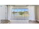 Bright, spacious room showcases sliding glass doors and a scenic view of the lake and landscape at 5492 Compass Pt, Oxford, FL 34484
