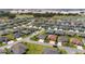 Neighborhood view showcasing mature trees, a golf course, and many homes with well-kept lawns at 560 Caputo Ct, The Villages, FL 32163
