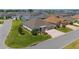 Aerial view of single-story home featuring landscaped lawns and paver driveway in quiet neighborhood at 560 Caputo Ct, The Villages, FL 32163