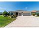 Attractive single-story home featuring a decorative driveway and well-kept lawn at 560 Caputo Ct, The Villages, FL 32163