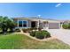 Charming single-story home featuring a beautifully landscaped front yard and a two-car garage at 560 Caputo Ct, The Villages, FL 32163