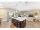 Bright open-concept kitchen features a large island with pendant lighting and modern finishes at 560 Caputo Ct, The Villages, FL 32163