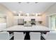 Bright, open kitchen featuring white cabinetry, stainless steel appliances, and a large island with seating at 560 Caputo Ct, The Villages, FL 32163
