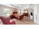 Comfortable main bedroom showcasing tray ceilings, tile floors, and complemented by a dresser and nightstands at 560 Caputo Ct, The Villages, FL 32163