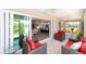 Relax on the covered patio with red wicker chairs, offering a seamless transition to the indoors at 560 Caputo Ct, The Villages, FL 32163
