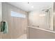 Bright walk-in shower boasts beige tile, a shower head, and glass door at 560 Caputo Ct, The Villages, FL 32163