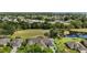 Scenic aerial view with lake, large field, and homes in a beautiful lakeside community at 579 Juniper Way, Tavares, FL 32778