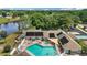 Aerial view of community pool, patio, and clubhouse with solar panels on a sunny day at 579 Juniper Way, Tavares, FL 32778