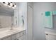 Bright bathroom with a large mirror, white vanity, and tiled shower in a well-lit space at 579 Juniper Way, Tavares, FL 32778