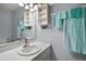Comfortable bathroom with modern lighting fixtures, sink, mirror and wall storage at 579 Juniper Way, Tavares, FL 32778