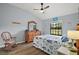 Well-lit bedroom featuring wood floor, a ceiling fan, window views and beach-themed decor at 579 Juniper Way, Tavares, FL 32778