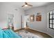Bedroom features a futon, window, wood floor, and easy access to a bathroom and hallway at 579 Juniper Way, Tavares, FL 32778