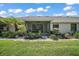 Outdoor patio with a screened in lanai surrounded by beautiful landscaping and plush green grass at 579 Juniper Way, Tavares, FL 32778