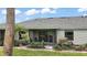 Home's rear view highlighting the screened lanai, manicured lawn, and lush landscaping at 579 Juniper Way, Tavares, FL 32778