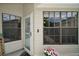 Front door with glass and storm door and nearby windows at 579 Juniper Way, Tavares, FL 32778
