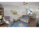 Living room with vaulted ceiling, wood floor, ceiling fan, and access to the dining room and kitchen at 579 Juniper Way, Tavares, FL 32778