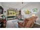 Comfortable living room has wood floors, a ceiling fan, sliding glass doors to the porch and a view of the outdoors at 579 Juniper Way, Tavares, FL 32778