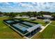 Community aerial showcasing tennis and bocce ball courts, offering residents diverse recreational opportunities amid manicured lawns at 5818 Greenbriar Loop, Leesburg, FL 34788