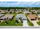 Aerial view of homes in a quiet residential neighborhood with well-manicured lawns and mature trees at 5818 Greenbriar Loop, Leesburg, FL 34788