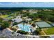 Aerial view of community clubhouse, pool, parking and recreational areas surrounded by green space and ponds at 5818 Greenbriar Loop, Leesburg, FL 34788