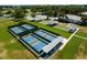 Community aerial showcasing tennis and bocce ball courts, providing diverse recreational opportunities amid meticulously kept lawns at 5818 Greenbriar Loop, Leesburg, FL 34788