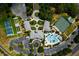 Aerial view of a community center featuring pools, tennis courts, and well-manicured landscapes at 5818 Greenbriar Loop, Leesburg, FL 34788