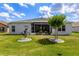 Beautiful backyard with screened-in porch, green lawn, young trees, and tidy landscaping at 5818 Greenbriar Loop, Leesburg, FL 34788
