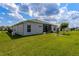 Well-maintained backyard features a screened lanai, green lawn, and decorative landscaping at 5818 Greenbriar Loop, Leesburg, FL 34788