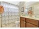 Well-lit bathroom with a vanity, toilet, and shower with stylish curtain at 5818 Greenbriar Loop, Leesburg, FL 34788