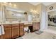 Elegant bathroom featuring double sinks, wooden cabinets, and a glass-enclosed shower at 5818 Greenbriar Loop, Leesburg, FL 34788