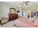 Spacious bedroom with a large dresser, seating area, and ensuite bathroom access at 5818 Greenbriar Loop, Leesburg, FL 34788