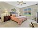 Bright bedroom featuring a ceiling fan, neutral walls, and a large window offering plenty of natural light at 5818 Greenbriar Loop, Leesburg, FL 34788