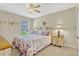Inviting bedroom featuring floral bedding, ceiling fan, and a bright window at 5818 Greenbriar Loop, Leesburg, FL 34788