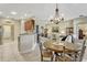 Open-concept dining area with chandelier, seamlessly connecting the kitchen and living room at 5818 Greenbriar Loop, Leesburg, FL 34788