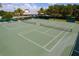 Aerial perspective of two tennis courts, nets in place, surrounded by green space, promising an active lifestyle at 5818 Greenbriar Loop, Leesburg, FL 34788