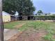 Backyard with mature trees and landscaping including a shed, storage, and a large grassy lawn at 604 N Old Wire Rd, Wildwood, FL 34785