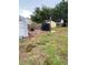 Backyard with a basketball hoop and court, shed, manicured landscaping and a spacious grassy lawn at 604 N Old Wire Rd, Wildwood, FL 34785
