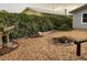 Landscaped backyard with rock, a fire pit, lush foliage and privacy hedges; a perfect outdoor relaxation space at 604 N Old Wire Rd, Wildwood, FL 34785