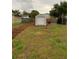 Backyard featuring a storage shed, landscaping, basketball area, and a lush, spacious grassy lawn at 604 N Old Wire Rd, Wildwood, FL 34785