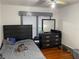 Comfortable bedroom features a full bed and dresser, illuminated by natural light from the window at 604 N Old Wire Rd, Wildwood, FL 34785