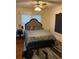 Cozy bedroom with hardwood floors, ceiling fan, and a comfortable bed with a decorative headboard at 604 N Old Wire Rd, Wildwood, FL 34785