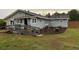 Charming single-story home featuring a backyard with grassy lawn and landscaping around the exterior of the home at 604 N Old Wire Rd, Wildwood, FL 34785