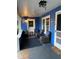 Inviting front porch with blue walls, wicker furniture, and decorative string lights at 604 N Old Wire Rd, Wildwood, FL 34785