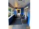 Inviting front porch with blue walls, wicker furniture, and decorative string lights at 604 N Old Wire Rd, Wildwood, FL 34785