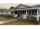 Inviting covered front porch with blue accents and concrete walkway leading to the entrance at 604 N Old Wire Rd, Wildwood, FL 34785