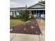 Charming home with blue accents, landscaping and concrete walkway leading to the front entrance at 604 N Old Wire Rd, Wildwood, FL 34785
