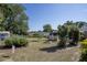 Landscaped backyard with a fire pit, swing, and a mix of trees and plants, ideal for outdoor enjoyment at 616 Third Ave, Lady Lake, FL 32159