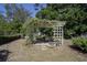 Backyard patio featuring a pergola with climbing vines and an outdoor dining area at 616 Third Ave, Lady Lake, FL 32159