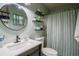 Bathroom featuring sleek floating shelves and a bright, round mirror above the sink at 616 Third Ave, Lady Lake, FL 32159